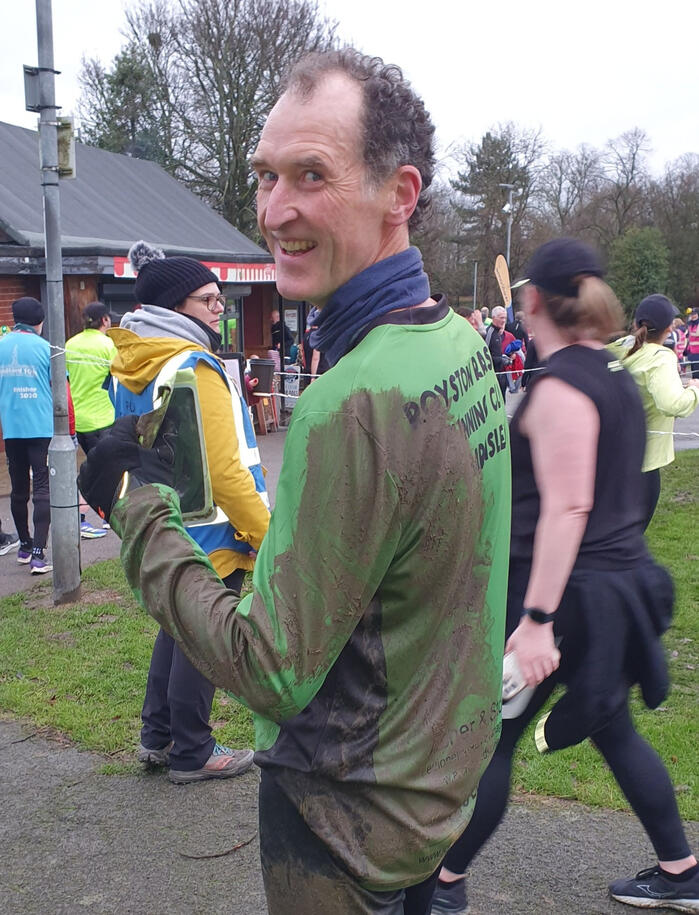 Man looking back at camera with muddy shirt